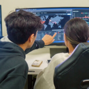 Cyber Security - two people in front of a monitor